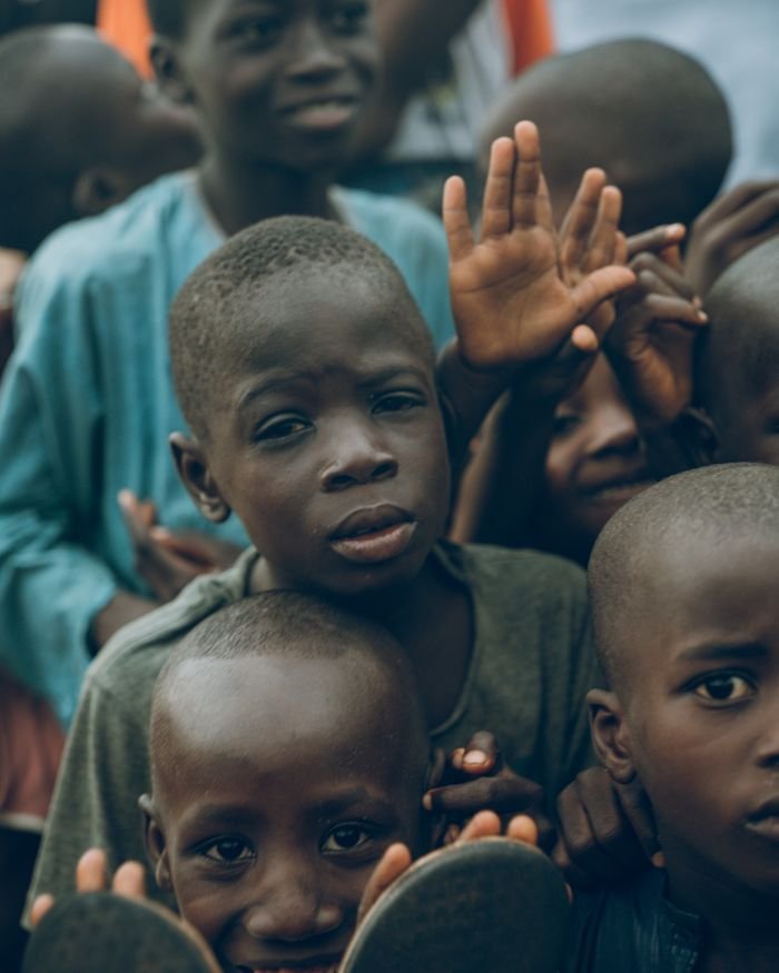 A heartwarming scene of Nigerian children gathering and expressing joy outdoors in a lively setting.